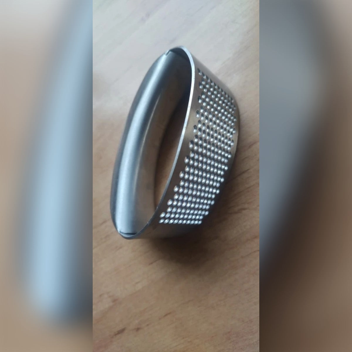 Köparbild: vitlökspressen i rostfritt stål sedd från sidan